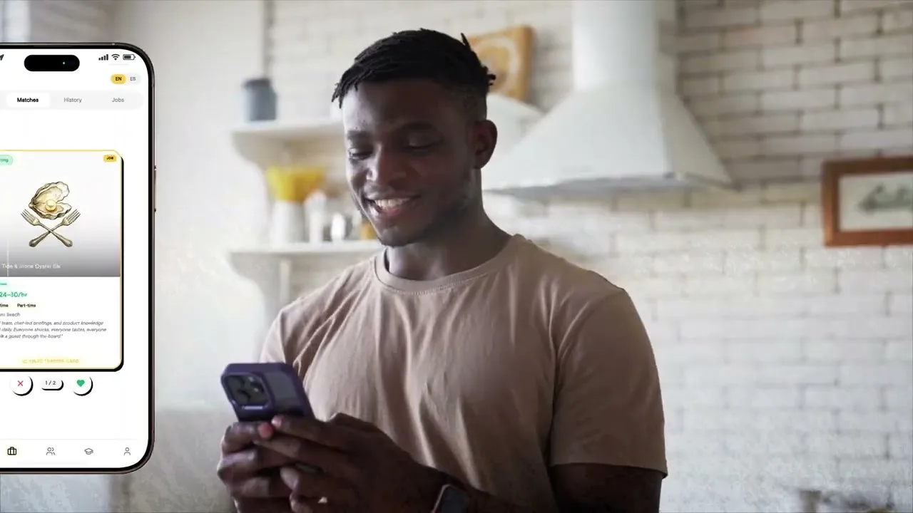 A hospitality worker checks his MAJC Trading Card on his phone in a kitchen